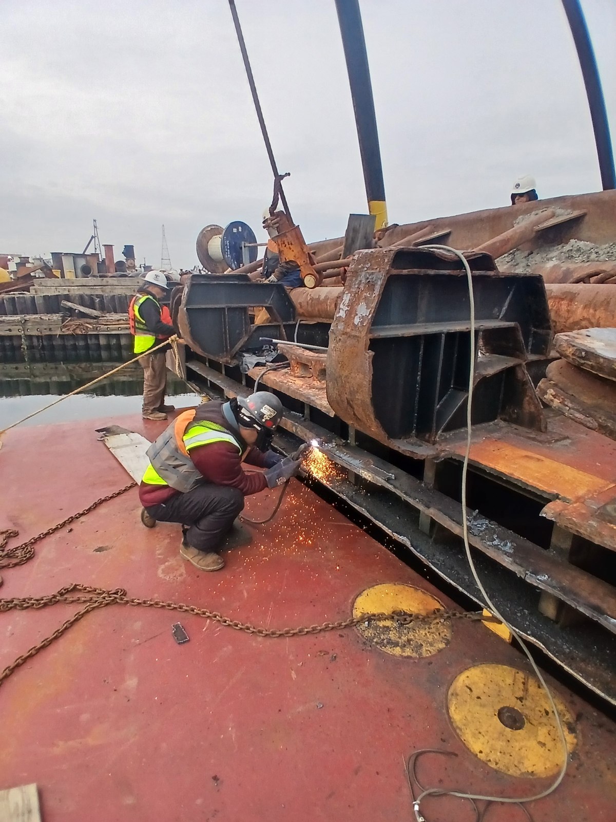 EA crew member working on GL-148 steel structure with arc and sparks visible